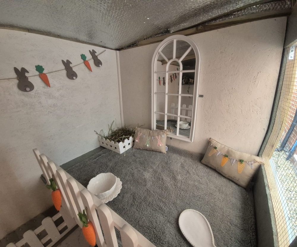 Upper level of a Resort with fleece, cushions, arched mirror and a hay box behind a picket fence